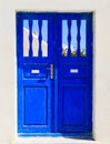 Blue wooden retro door on a whitewashed wall. Cyclades, Greece Royalty Free Stock Photo