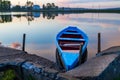 Blue wooden rowboat on water, evening during sunset and old boat Royalty Free Stock Photo