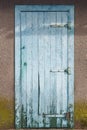 Blue wooden rusted textured door. Aged facade. Cracked wood