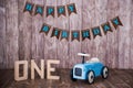 Blue wooden toy car on a wooden background. Decorative zone The first year. Royalty Free Stock Photo