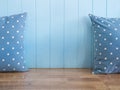 Blue wooden wall with polkadot pillows on wooden bench