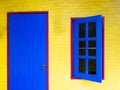 Blue Wooden Window and Door on The Red Frame in The Yellow Wall Royalty Free Stock Photo