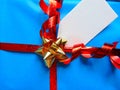 Blue wrapped gift with blank tag and pretty shiny ribbon Royalty Free Stock Photo