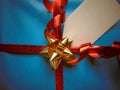 Blue wrapped gift with blank tag and pretty shiny ribbon Royalty Free Stock Photo