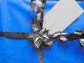 Blue wrapped gift with blank tag and pretty shiny ribbon Royalty Free Stock Photo