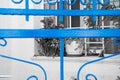 Blue wrought iron gate against monochrome window and wall