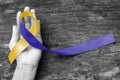 Blue yellow awareness ribbon on helping hand for World down syndrome day WDSD March 21 raising support on patient