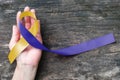 Blue yellow awareness ribbon on helping hand for World down syndrome day WDSD March 21 raising support on patient