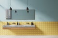 Blue and yellow bathroom interior with double sink and panoramic window