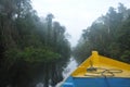 Blue and yellow boat floating on a dark river