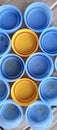 Blue and yellow bottle caps lined up in the daytime atmosphere