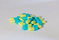 Blue and yellow capsules on white background