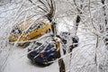Blue and yellow cars covered snow under tree  winter season. Snow storm Royalty Free Stock Photo