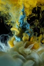 Blue and yellow color liquids injected underwater.