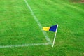 Blue yellow corner flag on a soccer field with green grass and white soccer field lines Royalty Free Stock Photo