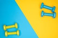 Blue and yellow dumbbells on blue and yellow background