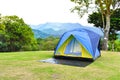 Yellow family camping tent with ground sheet setup on green park campsite