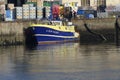 Blue and yellow Fishing boat alongside the wharf. Royalty Free Stock Photo