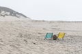 A blue and yellow folding chair on a beach