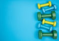 Blue, yellow and green dumbbells on blue background