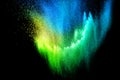 Blue yellow green powder explosion cloud isolated on black background Royalty Free Stock Photo