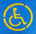 Blue and yellow handicap parking sign on asphalt, persons with disabilities Royalty Free Stock Photo