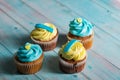 Blue and yellow handmade muffins on a blue wooden background