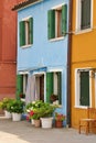 Blue and yellow house in Burano, small houses on a Venetian island, colourful houses, Italy, flowers in pots, wooden shutters, blo Royalty Free Stock Photo