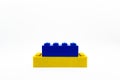 A blue and yellow little Lego block isolated on white background