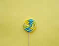 Blue yellow lollypop on yellow background