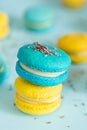Blue and yellow macaroons on a solid blue background, lavender flowers on the top Royalty Free Stock Photo