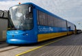 A blue and yellow passenger tram travels along Southport Pier October 2011