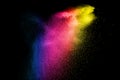 Blue yellow pink powder explosion cloud isolated on black background. Royalty Free Stock Photo