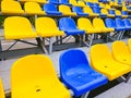 Blue and yellow plastic chairs on the street or at the stadium Royalty Free Stock Photo