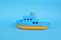 Blue and yellow plastic toy boat on blue