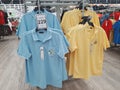 Blue and yellow polo shirts hanging on shelf for selling