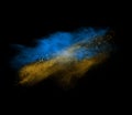 Blue and yellow powder explosion isolated on black Royalty Free Stock Photo