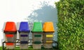 Yellow,blue, red and green recycle bin on the green floor in public park and white walls background Royalty Free Stock Photo