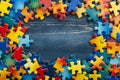 Blue, yellow, red pieces of puzzle frame on wooden background with copy space for text. World autism awareness day Royalty Free Stock Photo