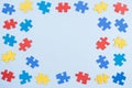 Blue, yellow, red pieces of puzzle on light blue frame background. World autism awareness day concept. Top view, copy Royalty Free Stock Photo