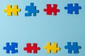 Blue, yellow, red pieces of puzzle on light blue frame background. World autism awareness day concept. Top view, copy Royalty Free Stock Photo