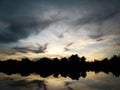 Blue and yellow sunset with clouds reflecting at the lake Royalty Free Stock Photo