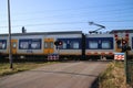 Blue yellow white sprinter train at a railroad crossing in Moordrecht