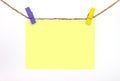 Blue wooden clip clamped the yellow note. Royalty Free Stock Photo