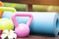 Blue yoga mat, kettlebell and a flower outdoor Royalty Free Stock Photo