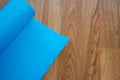 Blue yoga mat on wooden floor