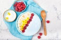 Blue yogurt smoothie bowl made with blue spirulina powder, fresh berries, banana and yellow flowers, top view Royalty Free Stock Photo