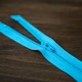 Blue zipper on dark wood background