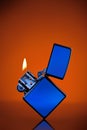 Blue zippo lighter on orange Royalty Free Stock Photo