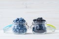 Blueberries and blackberries in a bowl on a white wooden table. Berries in a glass jug. Vegetarian food concept. Copy space, empty Royalty Free Stock Photo